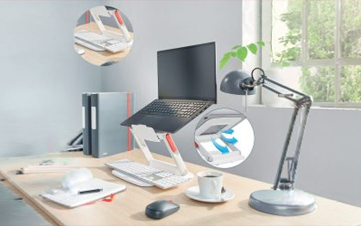 Ergonomikus irodai munkaállomás laptopállvánnyal, külső billentyűzettel és asztali lámpával.