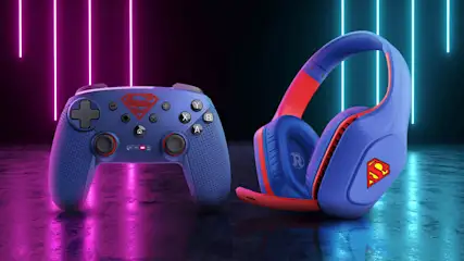 Kék és piros színű, Superman logóval díszített gamer kontroller és fejhallgató neonfényes, sötét háttér előtt, lila és kék fénycsíkokkal megvilágítva.