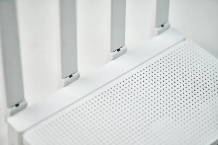 Közeli kép a Xiaomi router perforált fedlapjáról és az állítható antennák rögzítéséről.