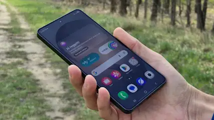 Samsung Galaxy S24 Ultra okostelefon kijelzője kézben tartva, döntött szögben a szabadban.