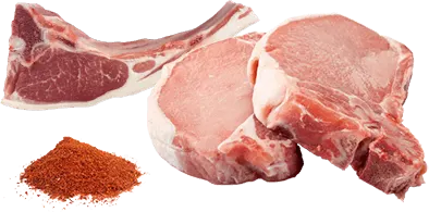 Három szelet nyers hús látható egy halom piros fűszerrel, fehér háttér előtt. A hús rózsaszín és vörös színű.