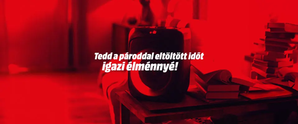 Vörös szín dominál, asztalon fekete tárgy, könyvek és felirat: "Tedd a pároddal eltöltött időt igazi élménnyé!".