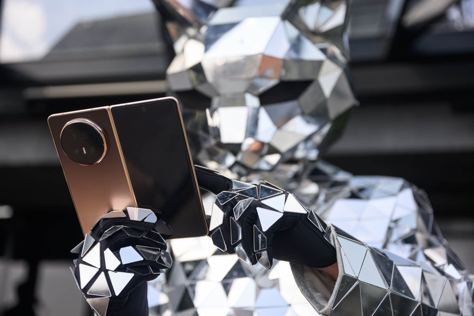 Tájat fotózó mobiltelefon, képernyőjén hegy, víz és zoom-állítás látható.