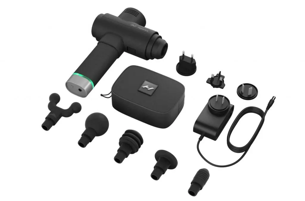 Fekete Hyperice Hypervolt 2 Pro masszázspisztoly a tartozékaival: öt cserélhető fejjel, hordozótáskával, töltővel és nemzetközi adapterekkel.