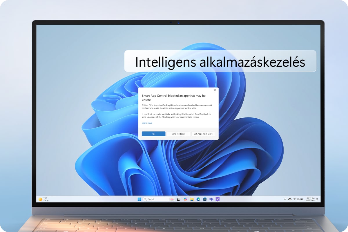 Laptop látható, képernyőjén "Intelligens alkalmazáskezelés" feliratú ablak és a Windows kék háttérképe. Egy üzenetablak is látható, ami egy blokkolt alkalmazásról szól.