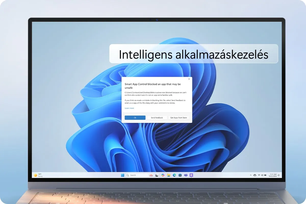 Laptop látható, képernyőjén "Intelligens alkalmazáskezelés" feliratú ablak és a Windows kék háttérképe. Egy üzenetablak is látható, ami egy blokkolt alkalmazásról szól.