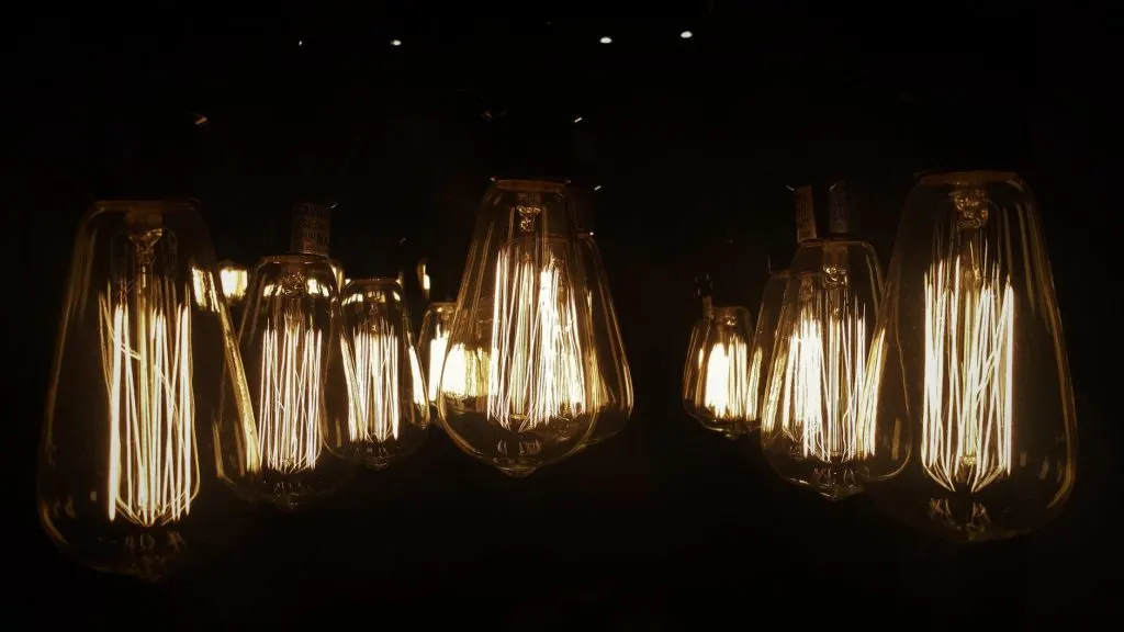 Melegen izzó, vintage stílusú Edison izzók sötét háttér előtt.
