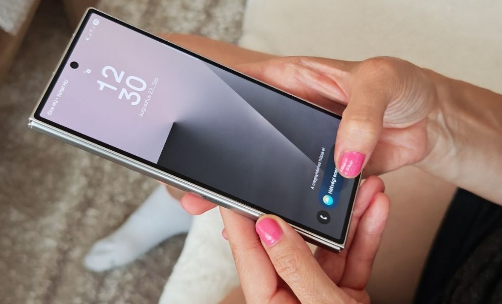 Kézben tartott Samsung Galaxy Z Fold okostelefon bekapcsolt külső kijelzővel és mindig aktív képernyő funkcióval.