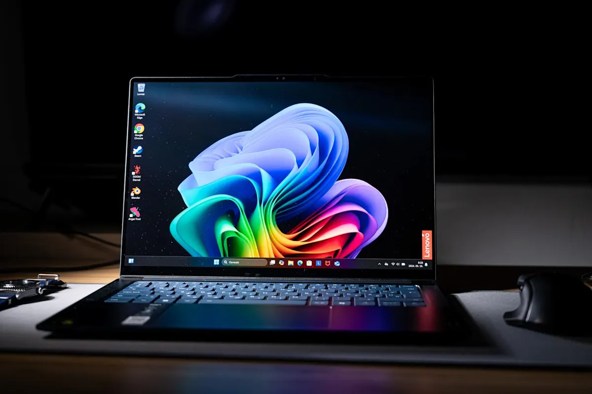 Lenovo Yoga Slim 7x bekapcsolt kijelzővel, Windows 11 háttérképpel és sötét környezetben.