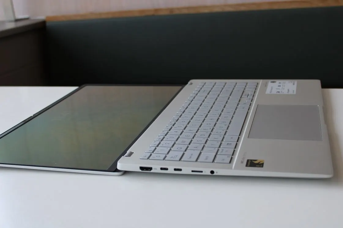 Ezüstszínű ASUS Vivobook S 15 laptop nyitott állapotban, színes háttérképpel és RGB világítású billentyűzettel.