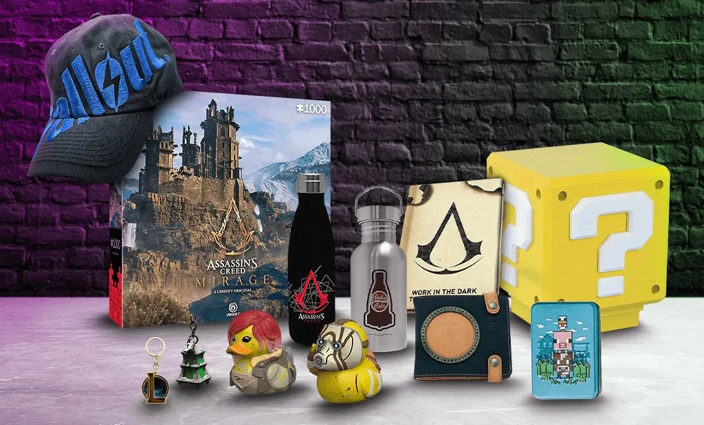 Különböző videójátékos ajándéktárgyak gyűjteménye egy téglafal előtt, többek között egy Assassin's Creed Mirage puzzle, Fallout sapka, Super Mario kérdőjeles lámpa, díszes kulacsok, gumikacsák és egy pénztárca.