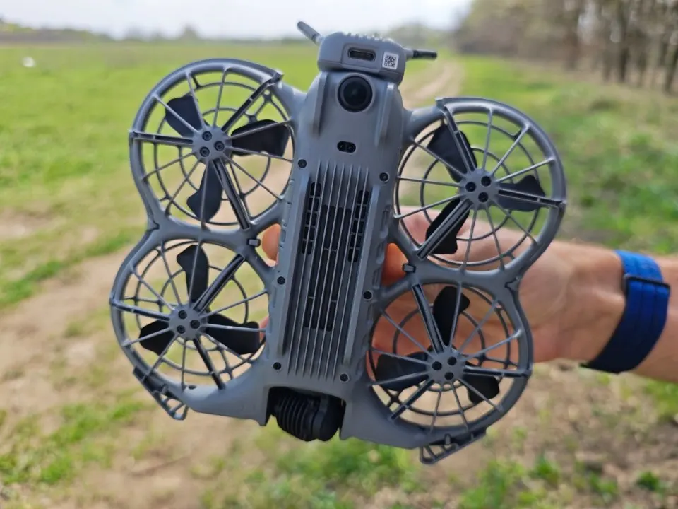 DJI Neo 2 drón aljának közeli képe a hűtőbordákkal és a propellervédőkkel.