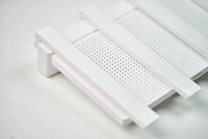 Felülnézet a Xiaomi router fehér házáról és a vízszintesen behajtott antennákról.