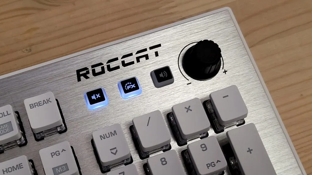 Roccat Vulcan billentyűzet multimédia vezérlői: gumi borítású hangerőszabályzó tárcsa és háttérvilágítással rendelkező funkciógombok közelről.