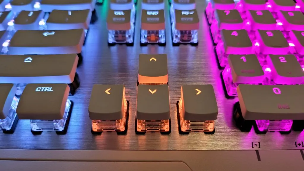 Közelkép a Roccat Vulcan mechanikus gamer billentyűzet áttetsző Titan kapcsolóiról és az egyedi RGB AIMO világításról.