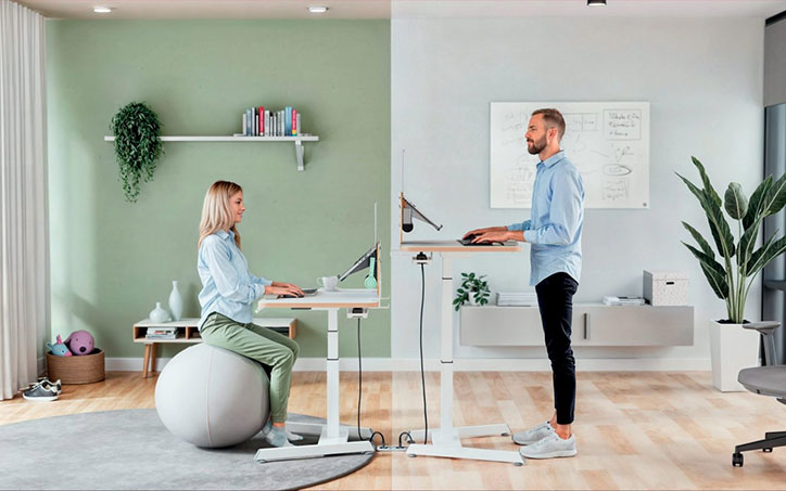 Ergonomikus irodai munkavégzés ülőlabdával és állítható magasságú asztallal modern környezetben.
