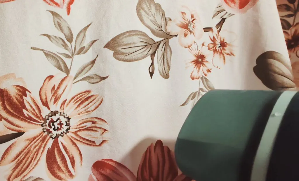 Virágmintás textil simítása Philips kézi gőzölővel használat közben.