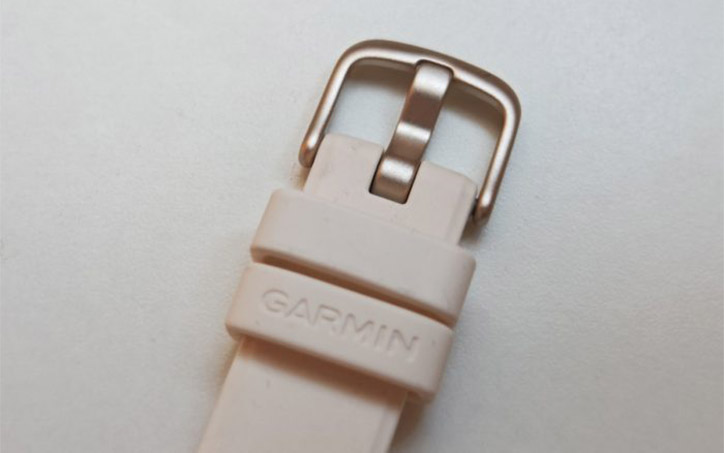 Garmin Lily 2 okosóra világos szilikon szíjának és csatjának közeli fotója.