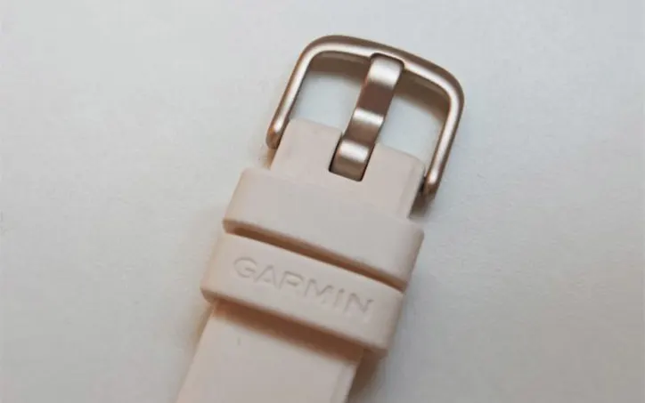 Garmin Lily 2 okosóra világos szilikon szíjának és csatjának közeli fotója.