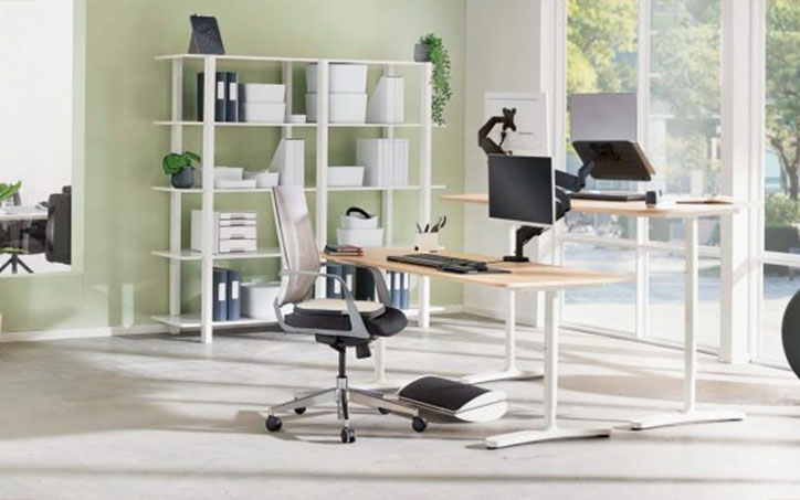 Modern ergonomikus iroda állítható magasságú íróasztallal, monitorállvánnyal és lábtámasszal.