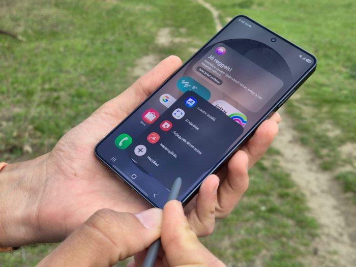 Samsung Galaxy okostelefon használata S Pen érintőceruzával és a megnyitott parancsikon menüvel a szabadban.