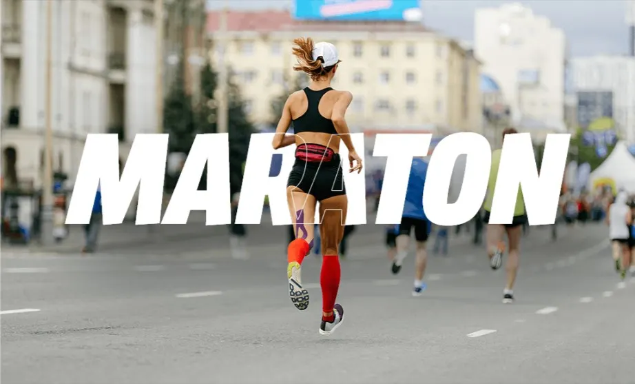 Női futó maratoni versenyen városi környezetben, hátulnézetből