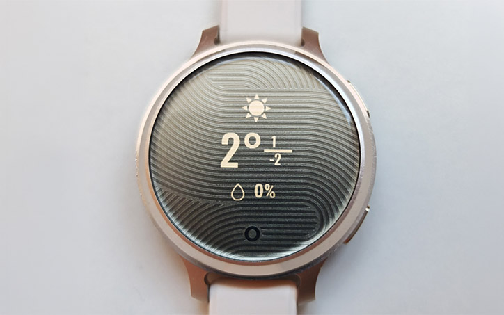 Garmin Lily 2 okosóra időjárás-kijelzővel, elegáns mintázott számlappal és világos szíjjal.