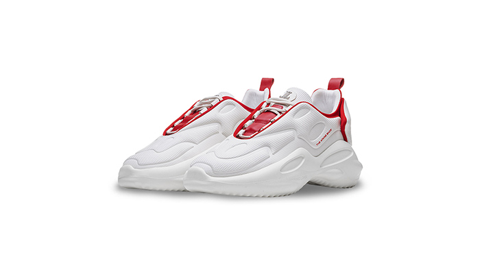 Zwei weiße Turnschuhe mit roten Akzenten stehen auf einem weißen Hintergrund. Die Schuhe sind nach links ausgerichtet.