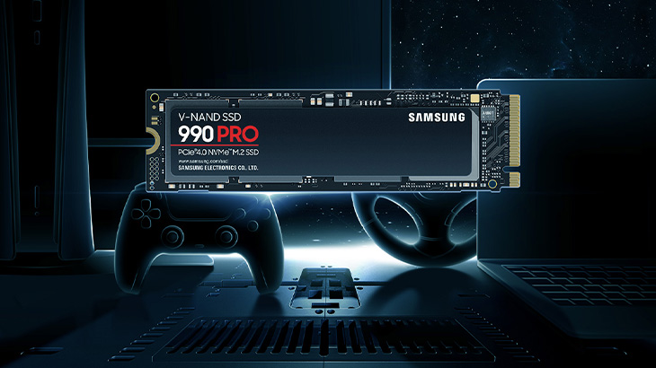 Eine Samsung 990 PRO SSD liegt vor einem Controller und einem Laptop auf einem dunklen Untergrund.