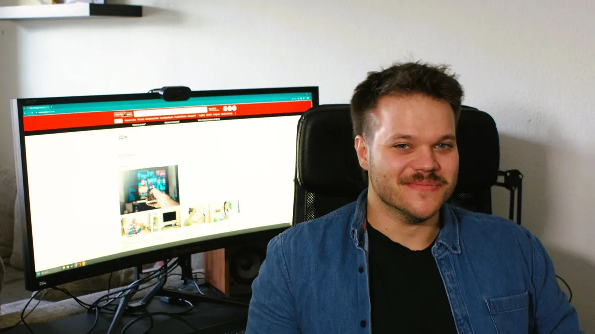 Lukas sitzt an seinem Schreibtisch vor seinem PC.