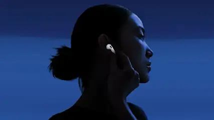 Eine Frau berührt einen AirPod 4 in ihrem rechten Ohr.