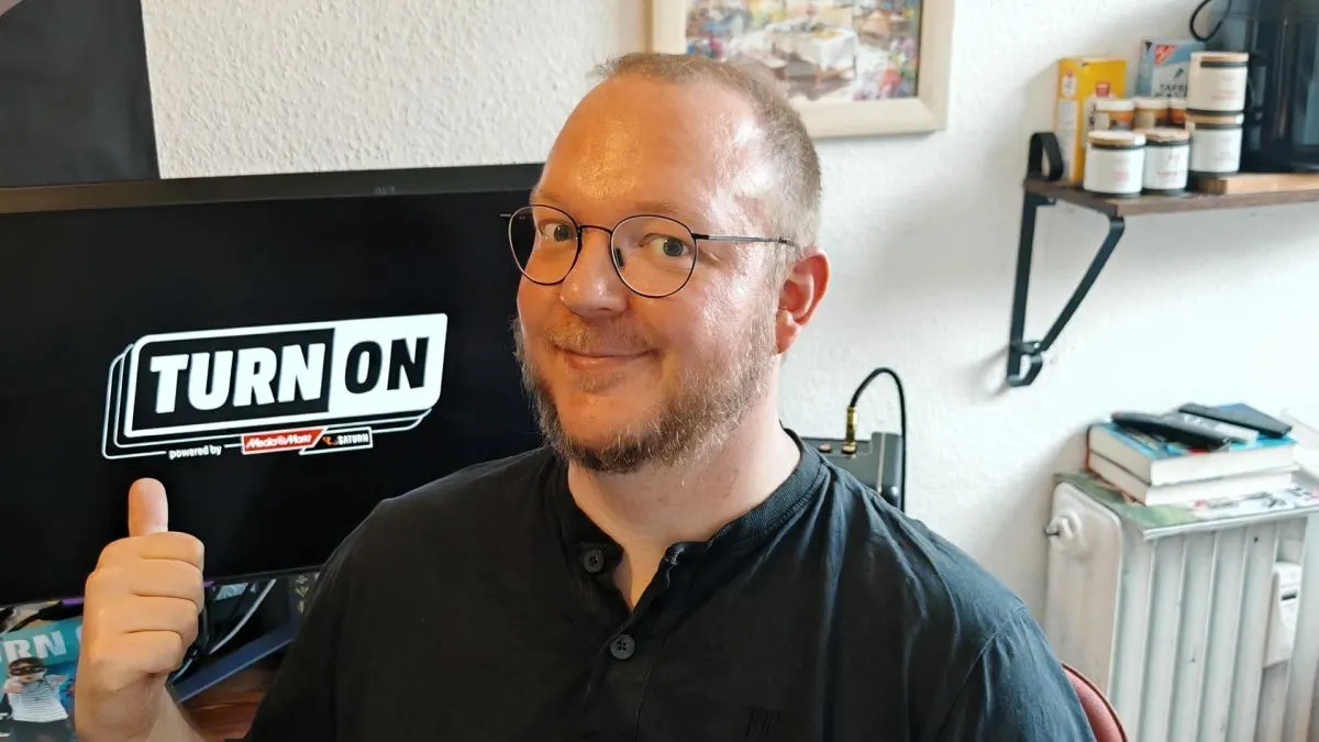 Andreas sitzt in seiner Küche vor einem OLED-Monitor.