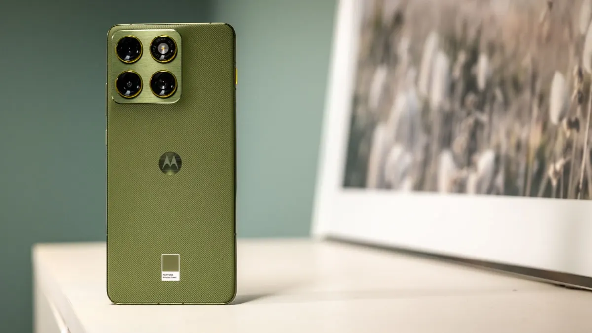 Das Motorola Edge 70 steht auf einem Tisch neben einem Bild.