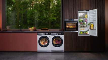 Eine Waschmaschine, Trockner, Backofen und ein Einbaukühlschrank aus der AEG EcoLine in einer modernen Küche. 