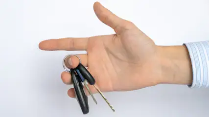 Eine Person hält einen Schlüsselbund in der Hand.