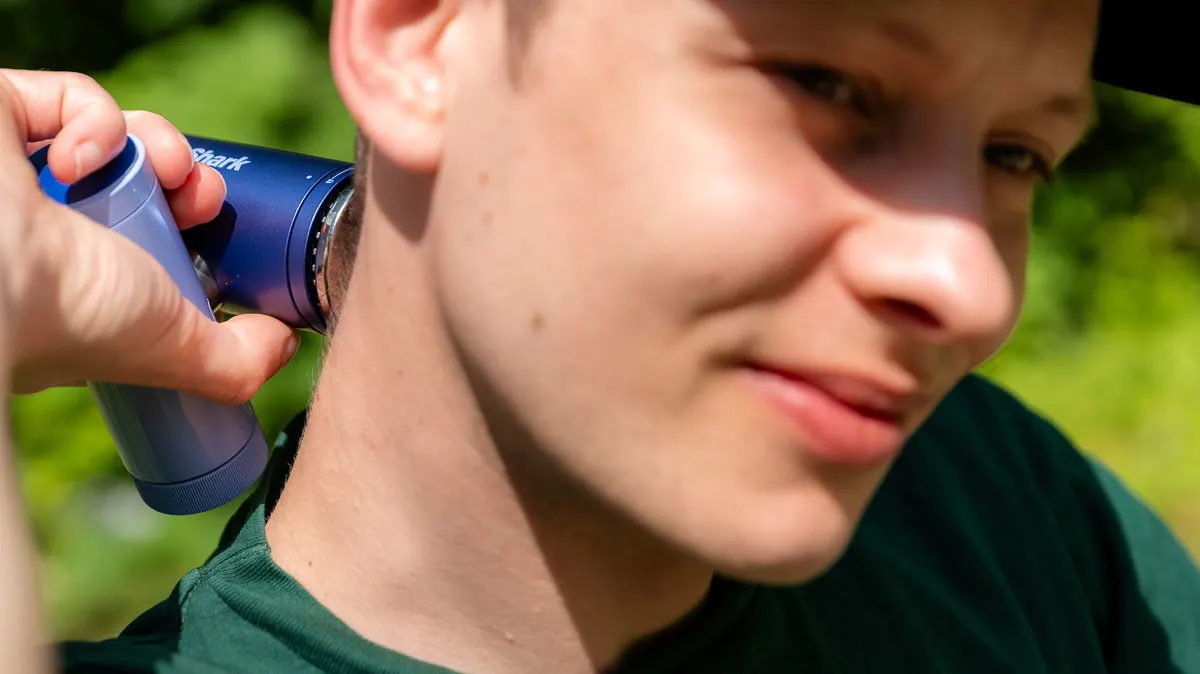 Alex kühlt sich den Nacken mit der InstaChill-Kühlplatte des Shark ChillPill.