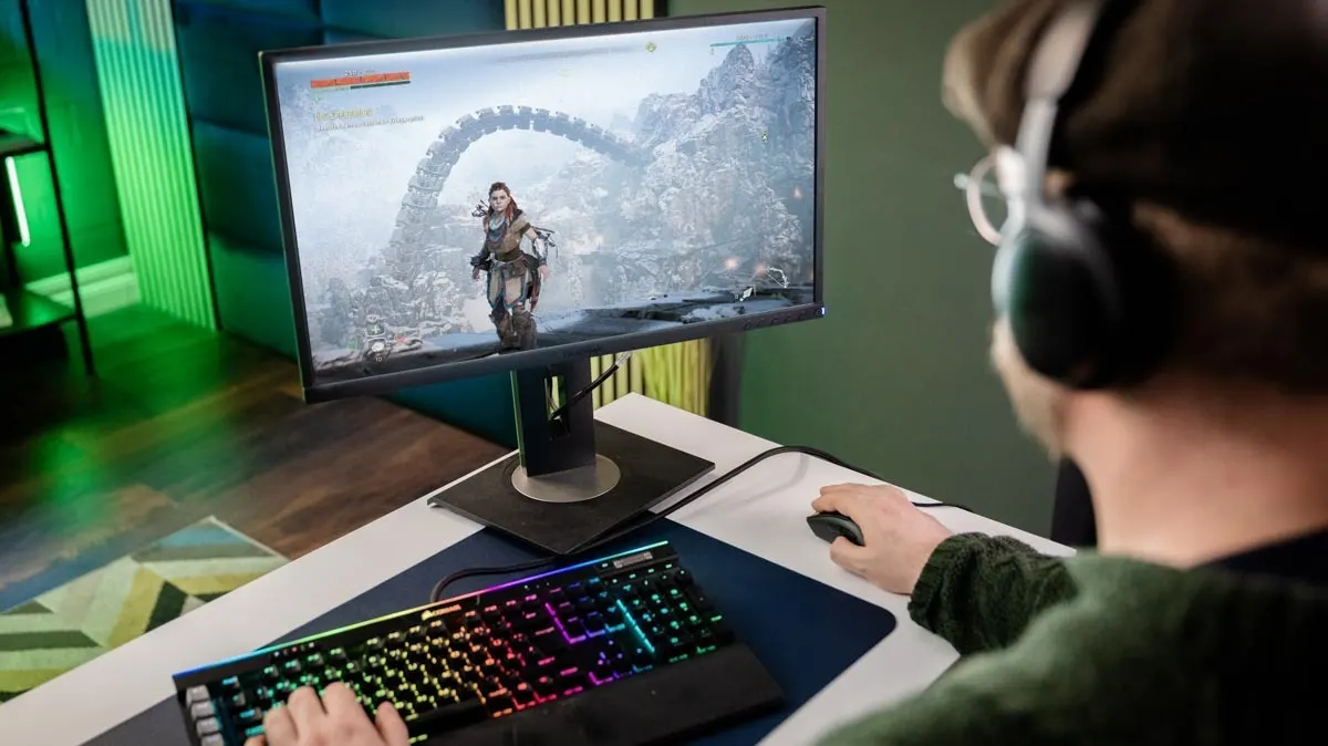 Andreas spielt „Horizon Zero Dawn“ mit der mechanischen Tastatur Corsair Gaming K95 RGB Platinum. Er ist schräg von hinten zu sehen, vor ihm ein Monitor.