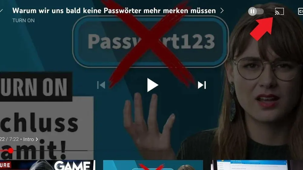 Ein Video-Screenshot zeigt eine Frau mit Brille vor einem blauen Bildschirm mit Passwort-Inhalten und einem roten Kreuz.