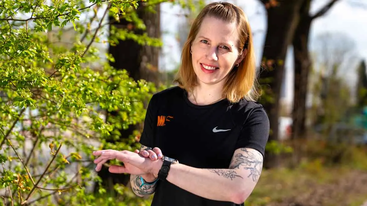Franzi trägt die Amazfit Active 3 Premium und startet draußen ein Lauftraining.