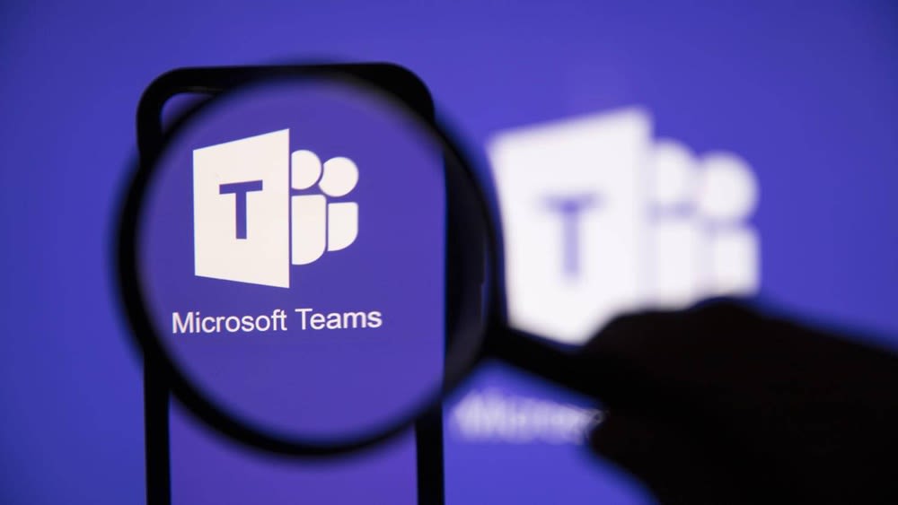 Das Microsoft-Teams-Logo wird mithilfe einer Lupe vergrößert.