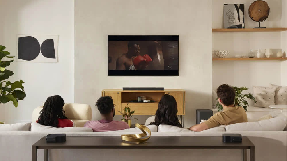 Familie sitzt vorm Fernseher mit kabellosen 5.1-System JBL Bar 1000.