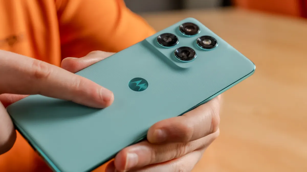 Michael berührt mit dem Zeigefinger die Rückseite des Motorola Edge 60 Fusion.