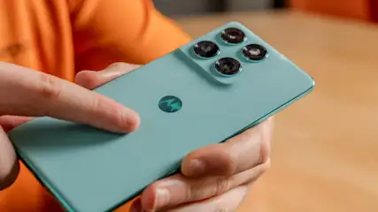 Michael berührt mit dem Zeigefinger die Rückseite des Motorola Edge 60 Fusion.