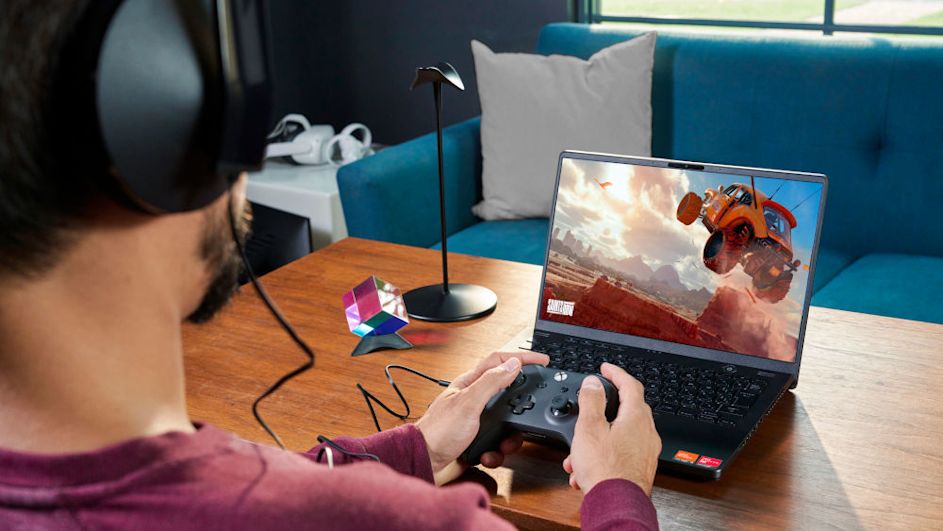Mann mit Headset spielt am Laptop mit Controller