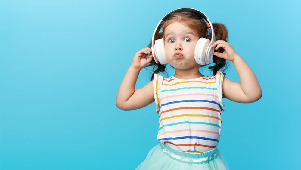 Ein Mädchen hört Musik mit Kinderkopfhörern