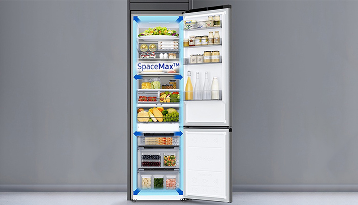 Ein Kühlschrank mit offener Tür zeigt Regale, die mit Lebensmitteln wie Gemüse, Obst und Getränken gefüllt sind.