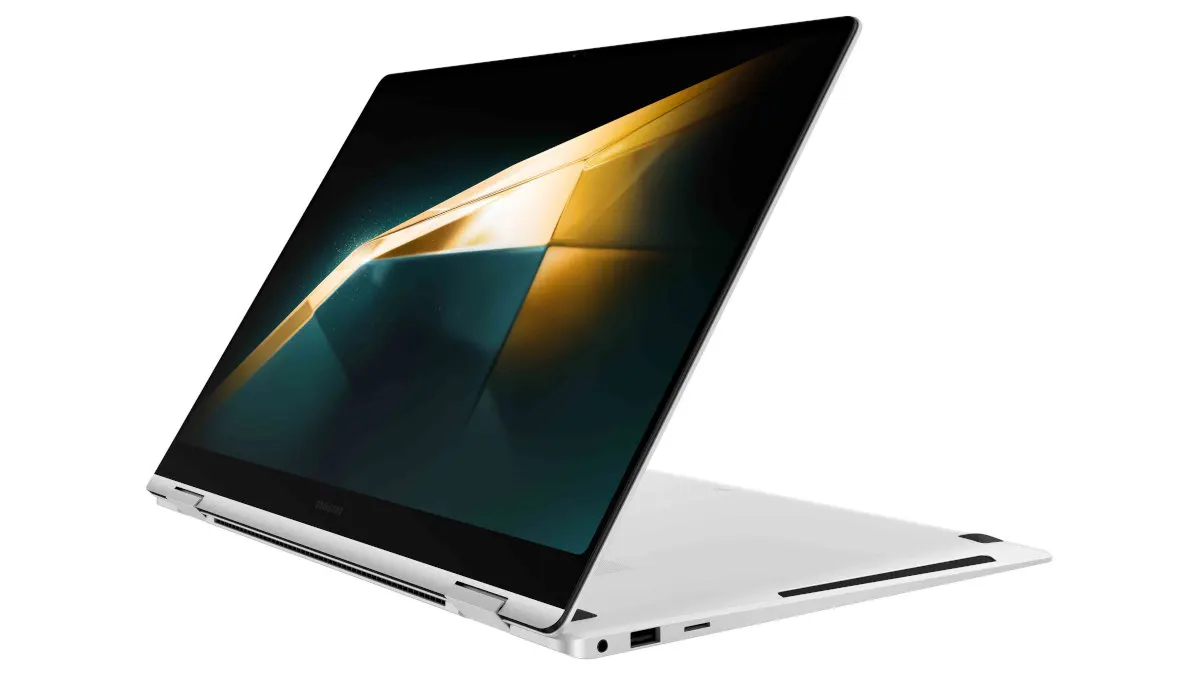 Ein geöffneter, silberfarbener Laptop steht auf einem weißen Untergrund. Der Bildschirm zeigt ein abstraktes, farbiges Muster.