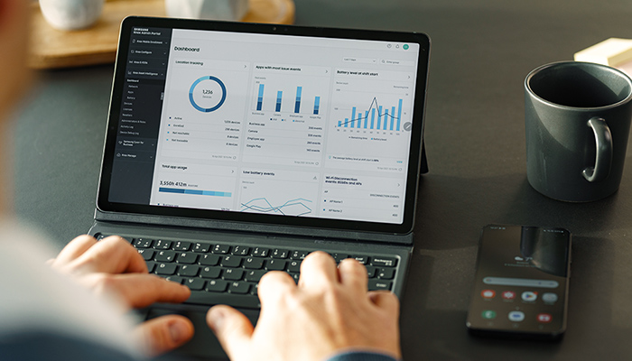 Ein Mann tippt etwas in sein aufgeklapptes Convertible.