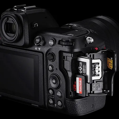 NIKON Z8 Gehäuse Systemkamera, 8 cm Display Touchscreen, WLAN Nahaufnahme einer schwarzen Kamera mit zwei Speicherkarten. Eine SanDisk-Karte mit 128 GB ist sichtbar. Mehrere Tasten sind auf der Seite der Kamera angeordnet.