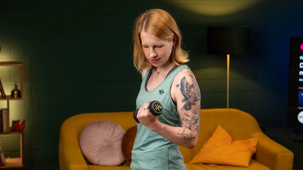 Franzi macht einen Curl mit einer Kurzhantel, am Zeigefinger trägt sie den Oura Ring 5.